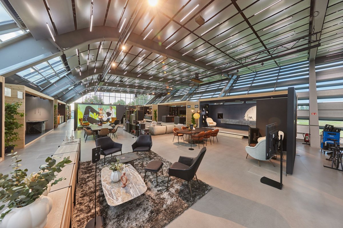 Mineralischer Fließestrich Betonoptik – Ausstellungshalle eines Einrichtungshauses mit grauem Designboden und modernem Interieur