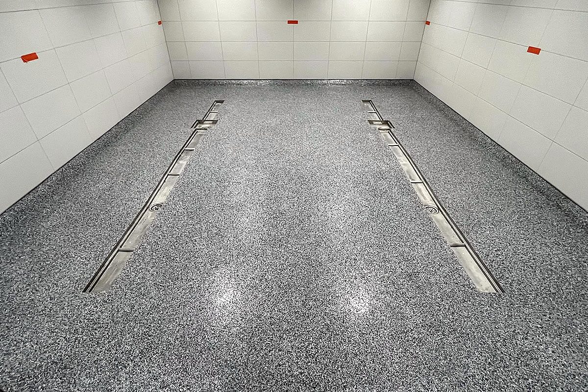 Großflächiger Sedimentboden mit zwei parallelen Edelstahlrinnen