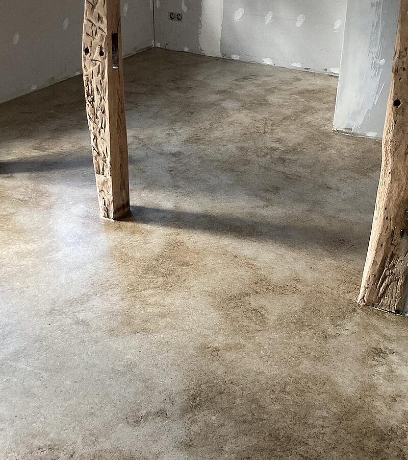 Sichtestrich frisch verlegt – sandbeiger Zementestrich im Rohbau mit Fachwerk-Holzstütze