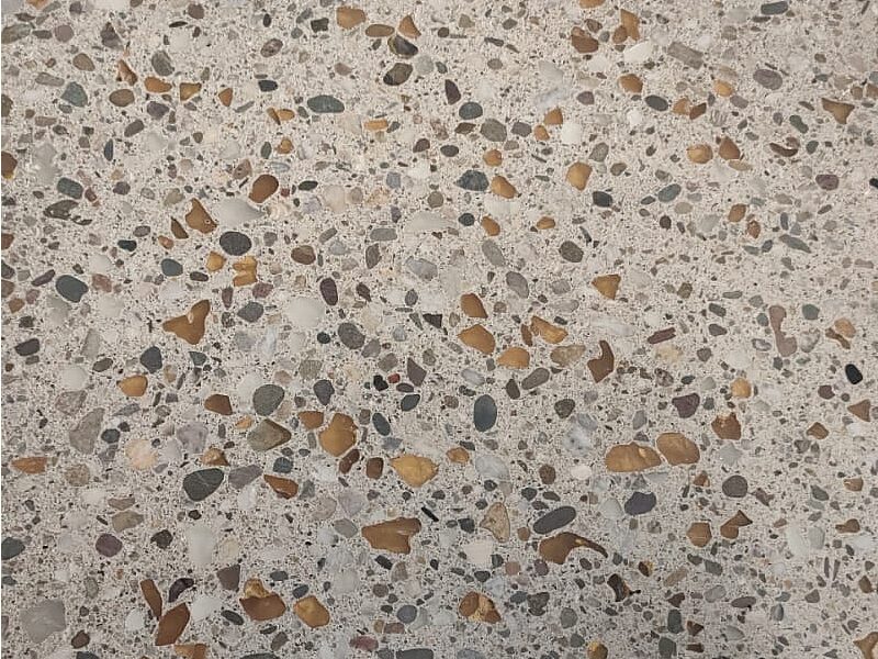 Nahaufnahme eines Terrazzobodens mit Kieseln in Beige- und Brauntönen