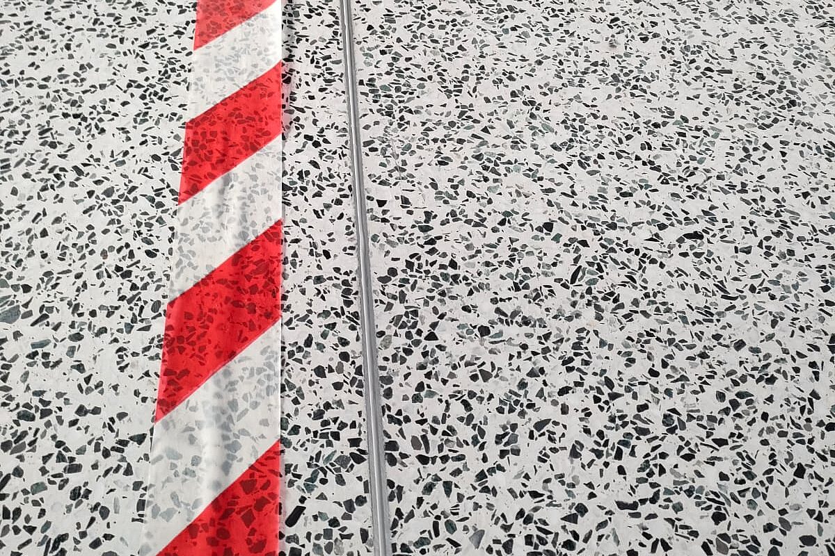 Terrazzoboden mit Edelstahlprofil und rotem Markierungsband