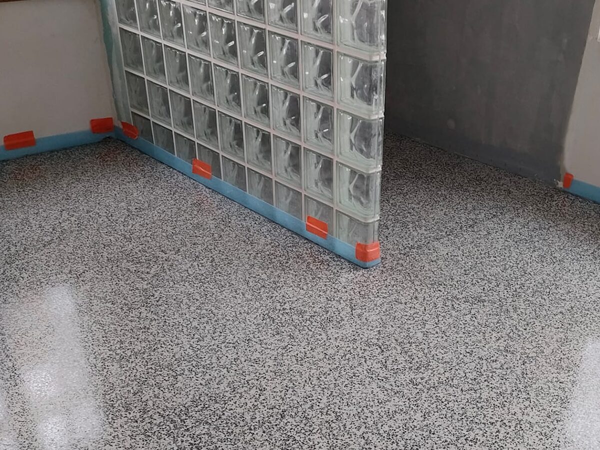 Heller Terrazzoboden in Kombination mit einer Glasbausteinwand