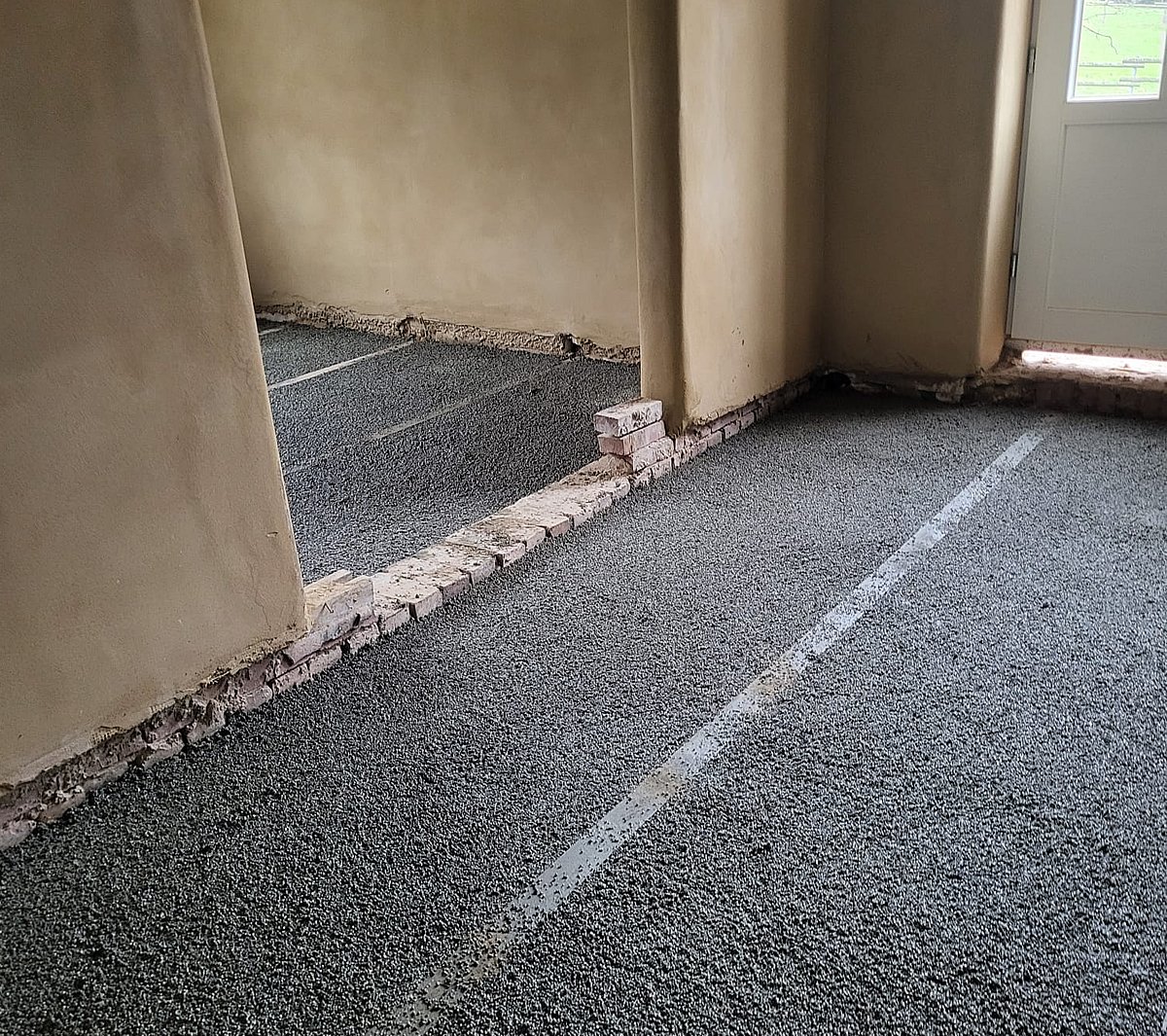 Ausgleichsschüttung im Altbau – Blähton-Schüttung mit Nivellierschienen in Wohnraum als Untergrund für neuen Estrich