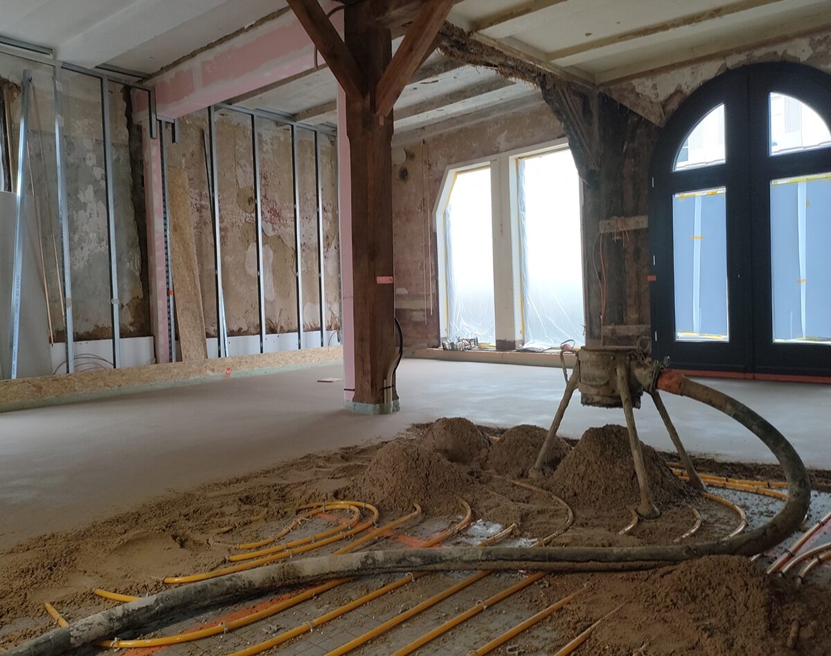 Frisch eingebauter Dünnschichtestrich in einem Altbau mit Rundbogentür