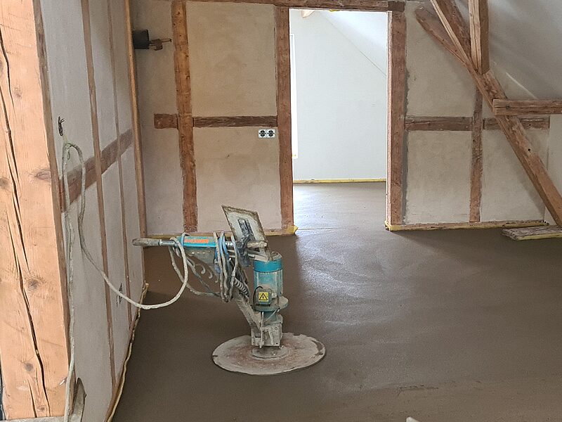 Glättmaschine auf frisch verlegtem Dünnschichtestrich in einem Fachwerkhaus