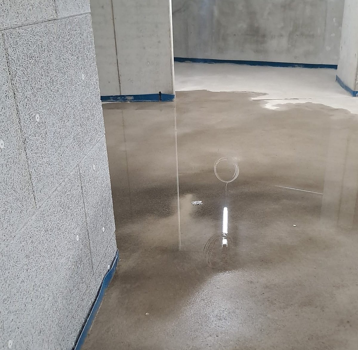 Estrich-Bautrocknung – Calciumsulfat-Fließestrich mit Trocknungssensor in Neubau-Rohbau mit Sichtbetonwänden und Randstreifen