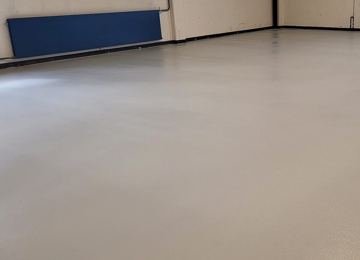 Fertig sanierter Hallenboden mit gleichmäßiger heller Beschichtung