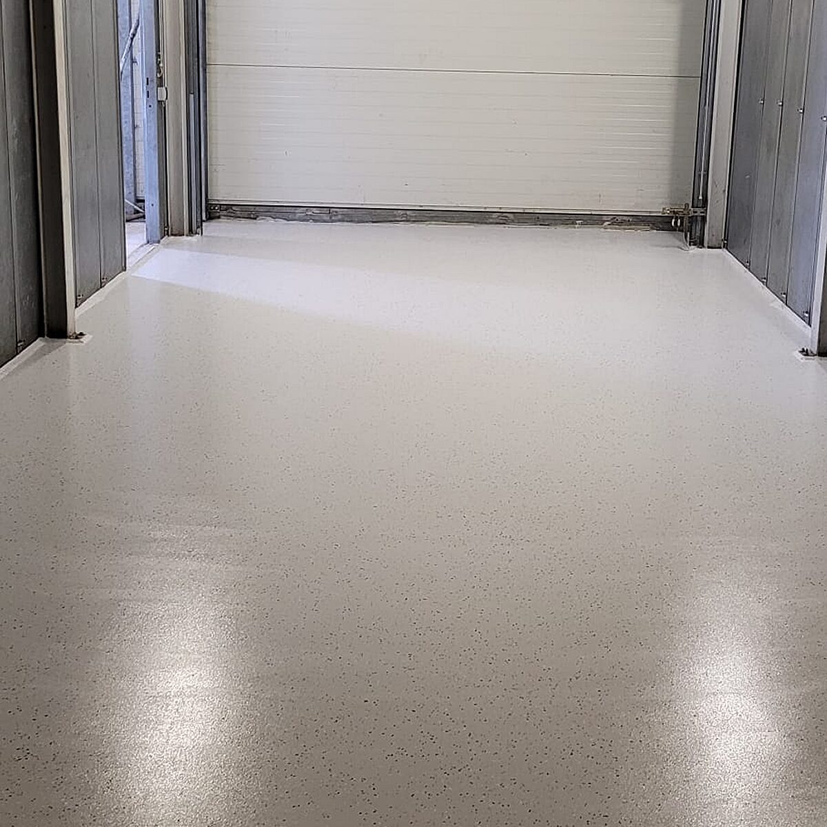 Fertig verlegte WHG-Beschichtung mit Farbchip-Einstreuung im Hallendurchgang