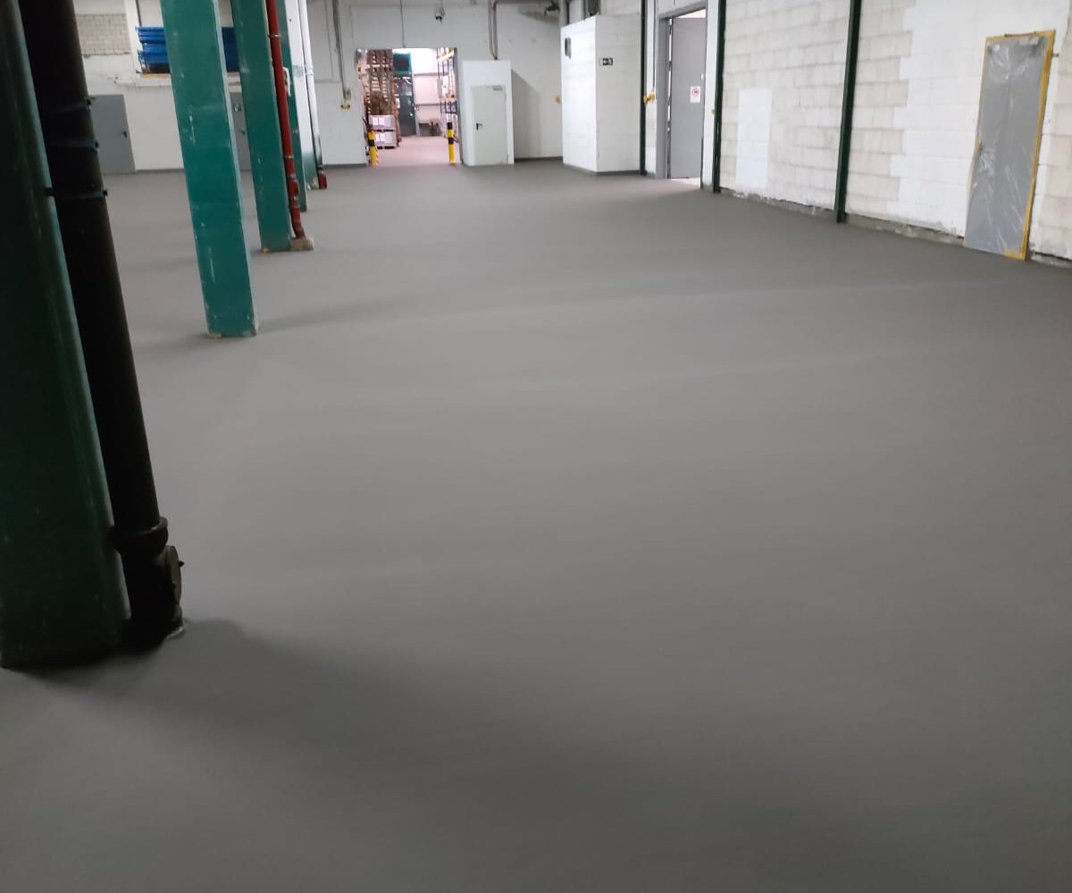 Frisch verlegter Zementfließestrich in einer Industriehalle