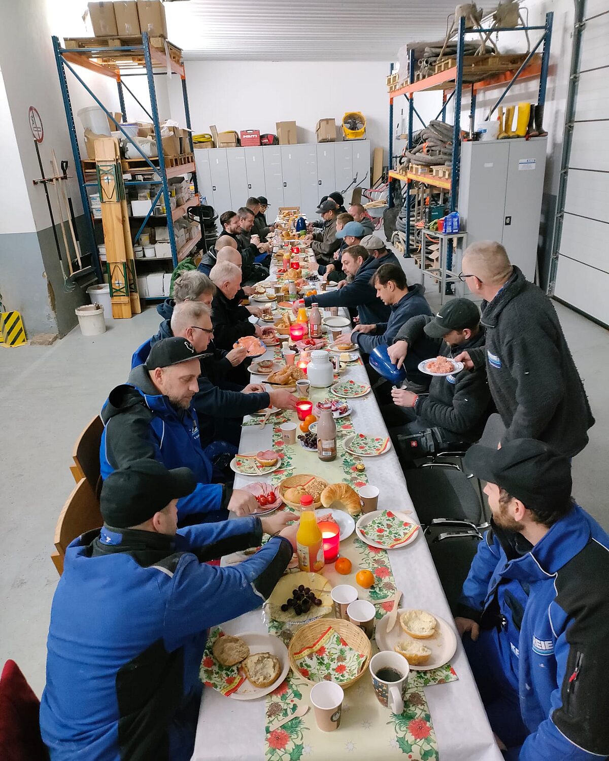 Weihnachtsfrühstück im Betrieb – Mitarbeiter feiern gemeinsam in der Produktionshalle.