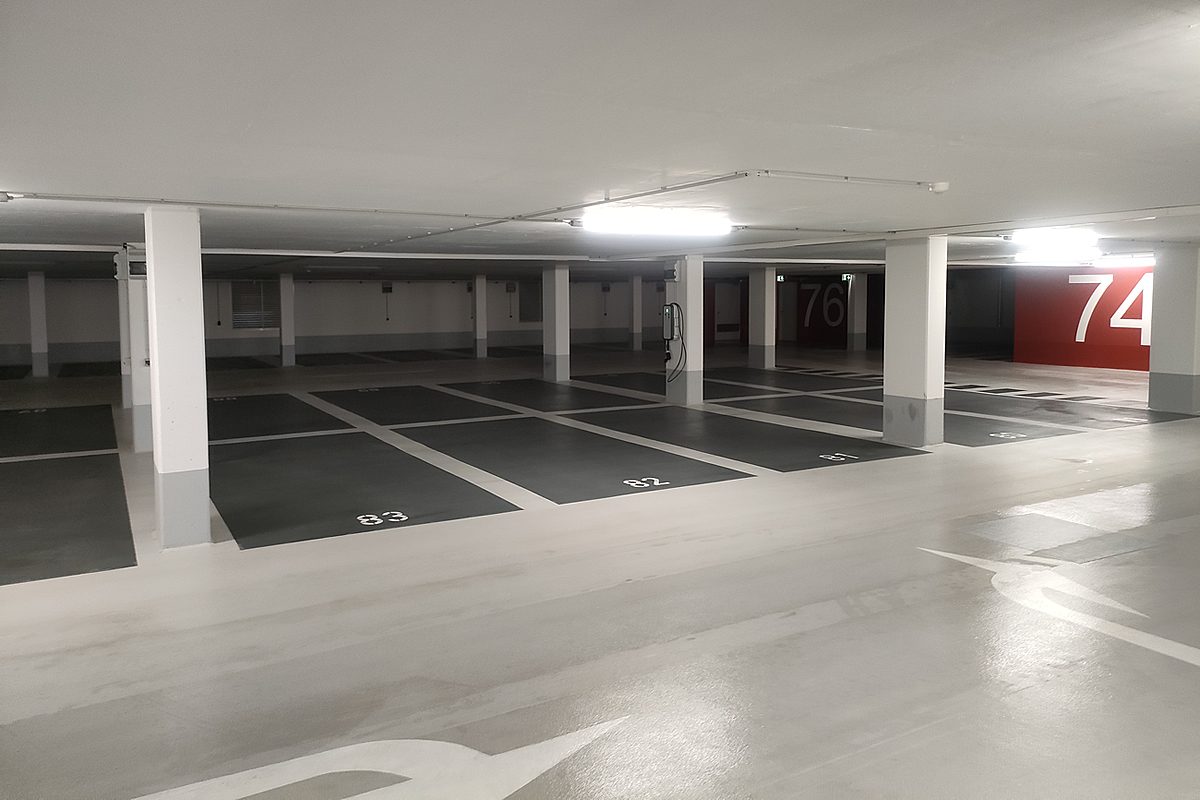 OS 8 Beschichtung Tiefgarage Hannover – heller Fahrweg mit weißem Richtungspfeil als Wegeleitsystem auf der hellgrauen Bodenfläche