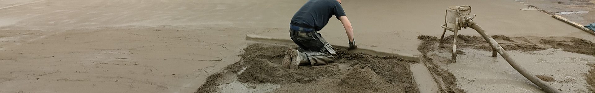 Schnellestrich – Mitarbeiter beim Einbau von Schnellestrich mit Pumpe und Abziehlatte in einer Industriehalle