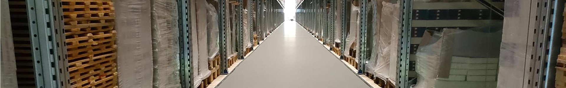 Zementfließestrich im Hochregallager – glatter Industrieboden zwischen hohen Palettenregalen