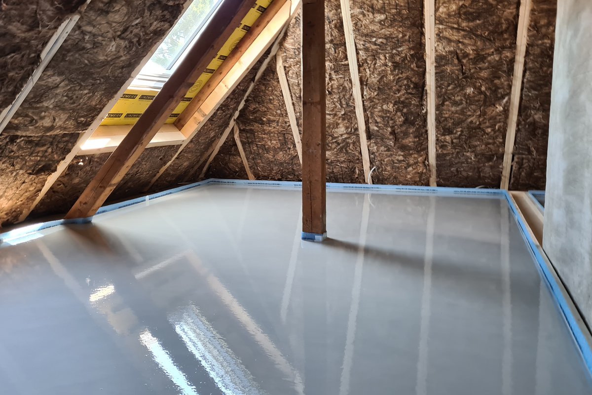 Dünnschichtestrich im Dachausbau – frisch verlegter Fließestrich im Dachgeschoss mit Dachschräge und Holzkonstruktion