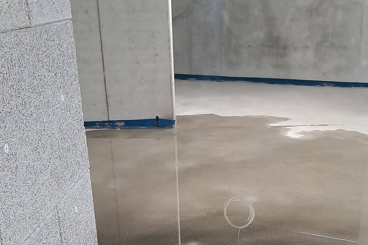 Estrich Bautrocknung – Calciumsulfat-Fließestrich frisch verlegt mit Randstreifen und Trocknungsmarkierungen in Altbauflur