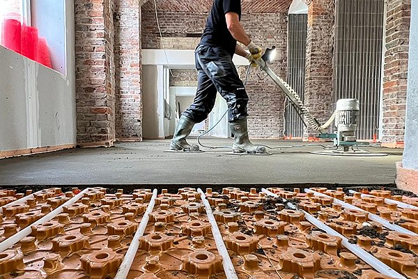 Schlüter-System Fußbodenheizung – Noppenmatte mit Heizrohren im historischen Backsteingebäude vor dem Estricheinbau